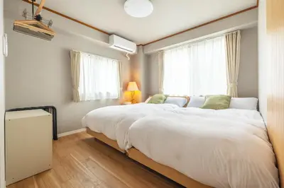 a large white bed in a room with a window at Home suite Home Ryogoku - Perfect for Families and Groups, Spacious 197m2 Home with 8 BR & 3 BA, Up to 15 ppl with Parking and 3 Stations in Tokyo