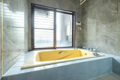 a yellow tub in a bathroom with a window at Home suite Home Ryogoku - Perfect for Families and Groups, Spacious 197m2 Home with 8 BR & 3 BA, Up to 15 ppl with Parking and 3 Stations in Tokyo