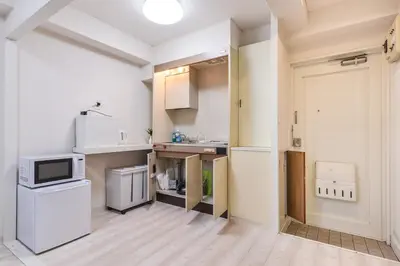 a small kitchen with white appliances in a room at \u30b5\u30f3\u30ef\u30a4\u30c9\u9ad8\u6a4b\u30d3\u30eb in Tokyo