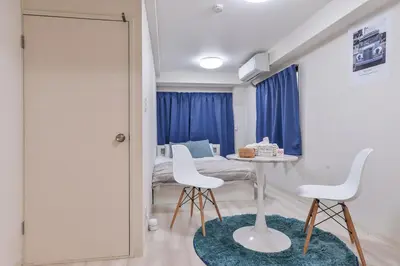 a room with a table and two white chairs at \u30b5\u30f3\u30ef\u30a4\u30c9\u9ad8\u6a4b\u30d3\u30eb in Tokyo