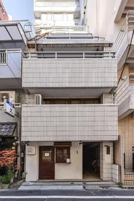 a building with a white tile facade with a door at \u30b5\u30f3\u30ef\u30a4\u30c9\u9ad8\u6a4b\u30d3\u30eb in Tokyo