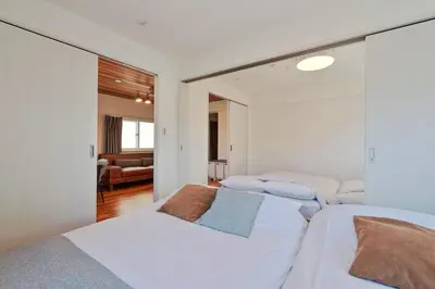 a bedroom with three beds and a living room at V Close to Shinjuku Kabukicho Korean Town FrWIFI M in Tokyo