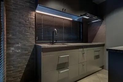 a kitchen with a sink and a brick wall at THE LIVRE Apartment Hotel in Tokyo