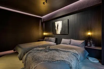 two beds in a room with purple lighting at THE LIVRE Apartment Hotel in Tokyo
