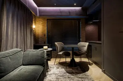 a living room with a couch and a table and chairs at THE LIVRE Apartment Hotel in Tokyo