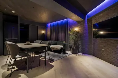 a dining room with a table and a couch at THE LIVRE Apartment Hotel in Tokyo
