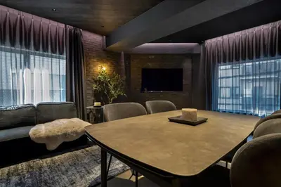 a living room with a table and chairs and a tv at THE LIVRE Apartment Hotel in Tokyo