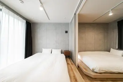 a bedroom with two beds and a window at Tabiya Shinamachi - New built APT at Ikebukuro, Relaxing Stay in Central Tokyo in Tokyo