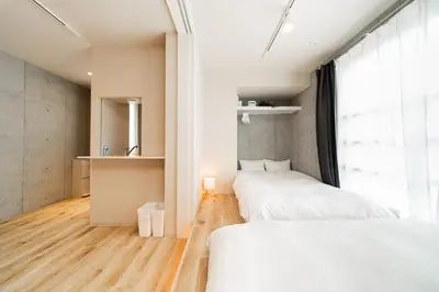 two beds in a room with a large window at Tabiya Shinamachi - New built APT at Ikebukuro, Relaxing Stay in Central Tokyo in Tokyo