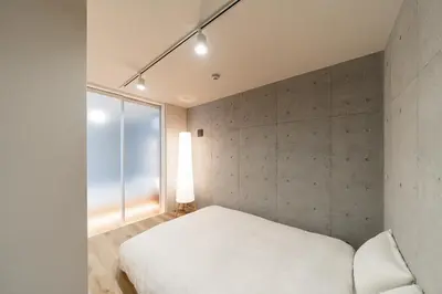 a bedroom with a white bed and a large window at Tabiya Shinamachi - New built APT at Ikebukuro, Relaxing Stay in Central Tokyo in Tokyo