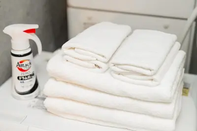 a stack of white towels on a bathroom counter at Tabiya Shinamachi - New built APT at Ikebukuro, Relaxing Stay in Central Tokyo in Tokyo