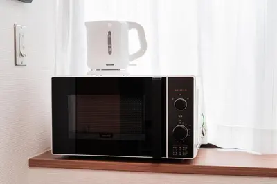 a microwave with a white cup on top of it at Luce Ikebukuro - Cozy APT Stay in Ikebukuro Tokyo, with Direct Access to Shinjuku & Shibuya in Tokyo
