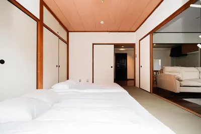a bedroom with two beds and a couch at Luce Ikebukuro - Cozy APT Stay in Ikebukuro Tokyo, with Direct Access to Shinjuku & Shibuya in Tokyo