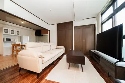 a living room with a white couch and a flat screen tv at Luce Ikebukuro - Cozy APT Stay in Ikebukuro Tokyo, with Direct Access to Shinjuku & Shibuya in Tokyo
