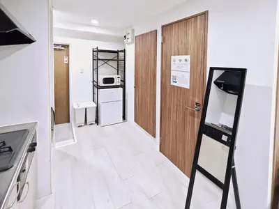 a small room with a kitchen with a door at Luce Ikebukuro - Cozy APT Stay in Ikebukuro Tokyo, with Direct Access to Shinjuku & Shibuya in Tokyo