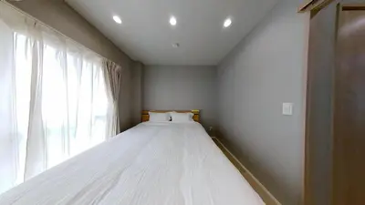 a large white bed in a room with a window at \u30db\u30c6\u30ebYado SK \u65b0\u5c0f\u5ca9 \u99c5\u5f92\u6b694\u5206 in Tokyo