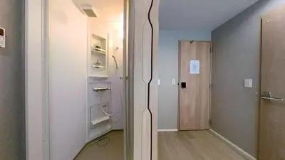 a hallway with a door leading into a room at \u30db\u30c6\u30ebYado SK \u65b0\u5c0f\u5ca9 \u99c5\u5f92\u6b694\u5206 in Tokyo