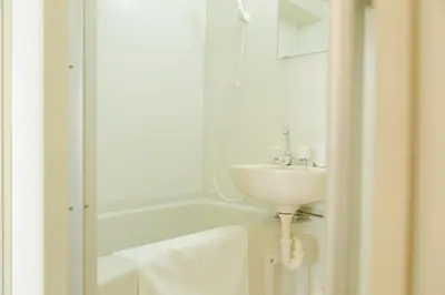 a white bathroom with a sink and a shower at Ikebukuro 302 - Twin Room in Tokyo