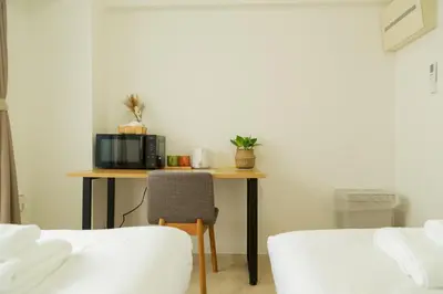 a room with a table with a microwave and a chair at Ikebukuro 302 - Twin Room in Tokyo
