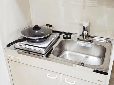 a kitchen with a sink and a pot on a stove at \u5927\u5c71\u6c11\u6cca \u6f2b\u753b\u5c0f\u5c4b \u6700\u59278\u4eba \u8907\u5f0f2\u5c64 \u6c60\u888b\u96fb\u8eca 5\u5206 in Tokyo