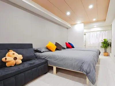 a living room with two beds and a couch at \u5927\u5c71\u99c5\u5f92\u6b698\u5206 \u6c60\u888b\u307e\u3067\u96fb\u8eca\u30675\u5206 \u6700\u59276\u4eba\u5bbf\u6cca in Tokyo