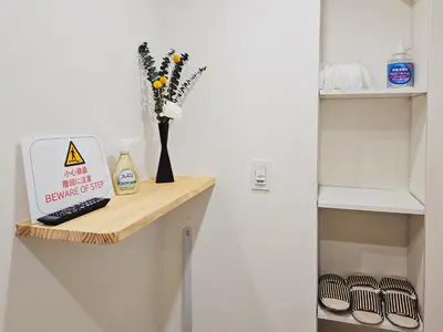 a shelf with a vase of flowers and a book at \u5927\u5c71\u99c5\u5f92\u6b698\u5206 \u6c60\u888b\u307e\u3067\u96fb\u8eca\u30675\u5206 \u6700\u59276\u4eba\u5bbf\u6cca in Tokyo
