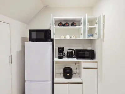 a kitchen with a refrigerator and a microwave at \u5927\u5c71\u99c5\u5f92\u6b698\u5206 \u6c60\u888b\u307e\u3067\u96fb\u8eca\u30675\u5206 \u6700\u59276\u4eba\u5bbf\u6cca in Tokyo