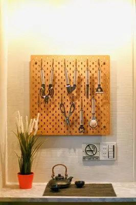 a pegboard with scissors hanging on a wall at \u5fa1\u4eac\u30db\u30c6\u30eb in Tokyo