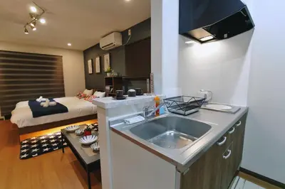 a kitchen with a sink and a room with a bed at \u5fa1\u4eac\u30db\u30c6\u30eb in Tokyo