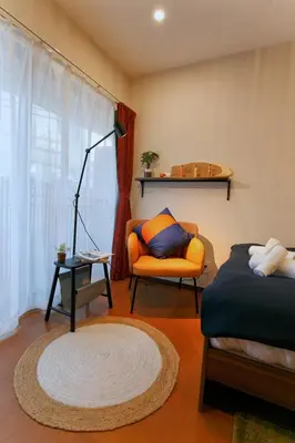 a bedroom with a bed and a chair and a lamp at \u5fa1\u4eac\u30db\u30c6\u30eb in Tokyo