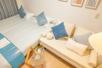 a large white bed with blue pillows on it at Near Shinjuku Nakano unit 3 Walking 4 Mins Broadway No2 in Tokyo