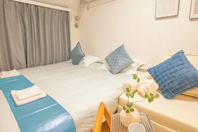 a bedroom with a large bed with blue and white pillows at Near Shinjuku Nakano unit 3 Walking 4 Mins Broadway No2 in Tokyo