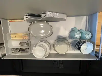a drawer filled with plates and utensils in a refrigerator at MU HOUSE Ikebukuro \u6c60\u888b\u99c5\u8eca1\u5206 in Tokyo