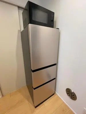 a microwave sitting on top of a refrigerator at MU HOUSE Ikebukuro \u6c60\u888b\u99c5\u8eca1\u5206 in Tokyo