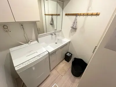 a white laundry room with a washer and a sink at MU HOUSE Ikebukuro \u6c60\u888b\u99c5\u8eca1\u5206 in Tokyo