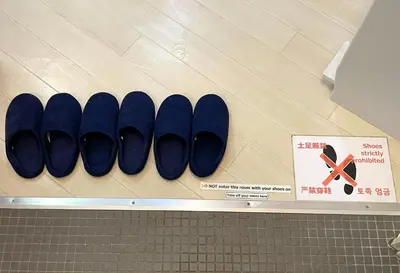 a row of blue shoes are lined up on a wall at Hot Deal! Simple, no-frills room 3 guest in Tokyo