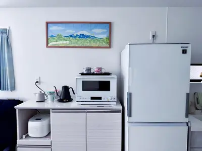a kitchen with a microwave and a refrigerator at Hao Bros Home Gemini in Tokyo
