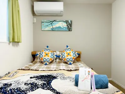 a bedroom with a bed with two blue and white vases at Hao Bros Home Gemini in Tokyo