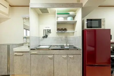 a kitchen with a red refrigerator and a sink at \u6771\u4eac\u99c5\u3084\u79cb\u8449\u539f\u99c5\u304b\u3089\u96fb\u8eca\u3067\u30a2\u30af\u30bb\u30b9\u826f\u597d in Tokyo
