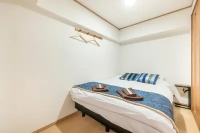 a bedroom with a bed with two shoes on it at \u6771\u4eac\u99c5\u3084\u79cb\u8449\u539f\u99c5\u304b\u3089\u96fb\u8eca\u3067\u30a2\u30af\u30bb\u30b9\u826f\u597d in Tokyo