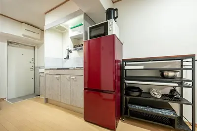 a red refrigerator with a microwave on top in a kitchen at \u6771\u4eac\u99c5\u3084\u79cb\u8449\u539f\u99c5\u304b\u3089\u96fb\u8eca\u3067\u30a2\u30af\u30bb\u30b9\u826f\u597d in Tokyo