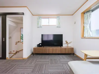 a living room with a flat screen tv on the wall at Four Seasons Yado 2 in Tokyo