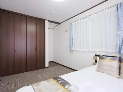 a bedroom with a bed and wooden cabinets at Four Seasons Yado 2 in Tokyo
