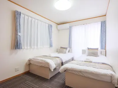 two beds in a room with a window at Four Seasons Yado 2 in Tokyo
