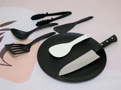 a black plate with a spatula and a knife and fork at Four Seasons Yado 2 in Tokyo