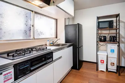 a kitchen with a sink and a black refrigerator at \u7573\u306e\u9593\u6c60\u888b in Tokyo