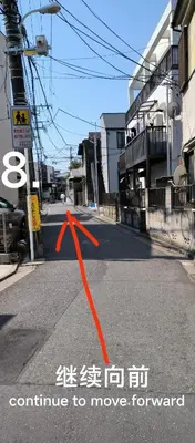an orange arrow on a road in a city at \u548c\u98ce\u5c45 in Tokyo