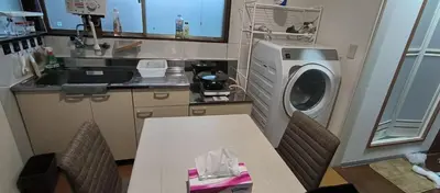 a kitchen with a washing machine and a table with chairs at \u548c\u98ce\u5c45 in Tokyo