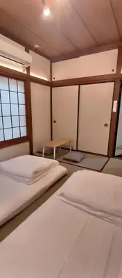 a room with two beds and a table in it at \u548c\u98ce\u5c45 in Tokyo
