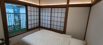 a small room with a bed and two windows at \u548c\u98ce\u5c45 in Tokyo